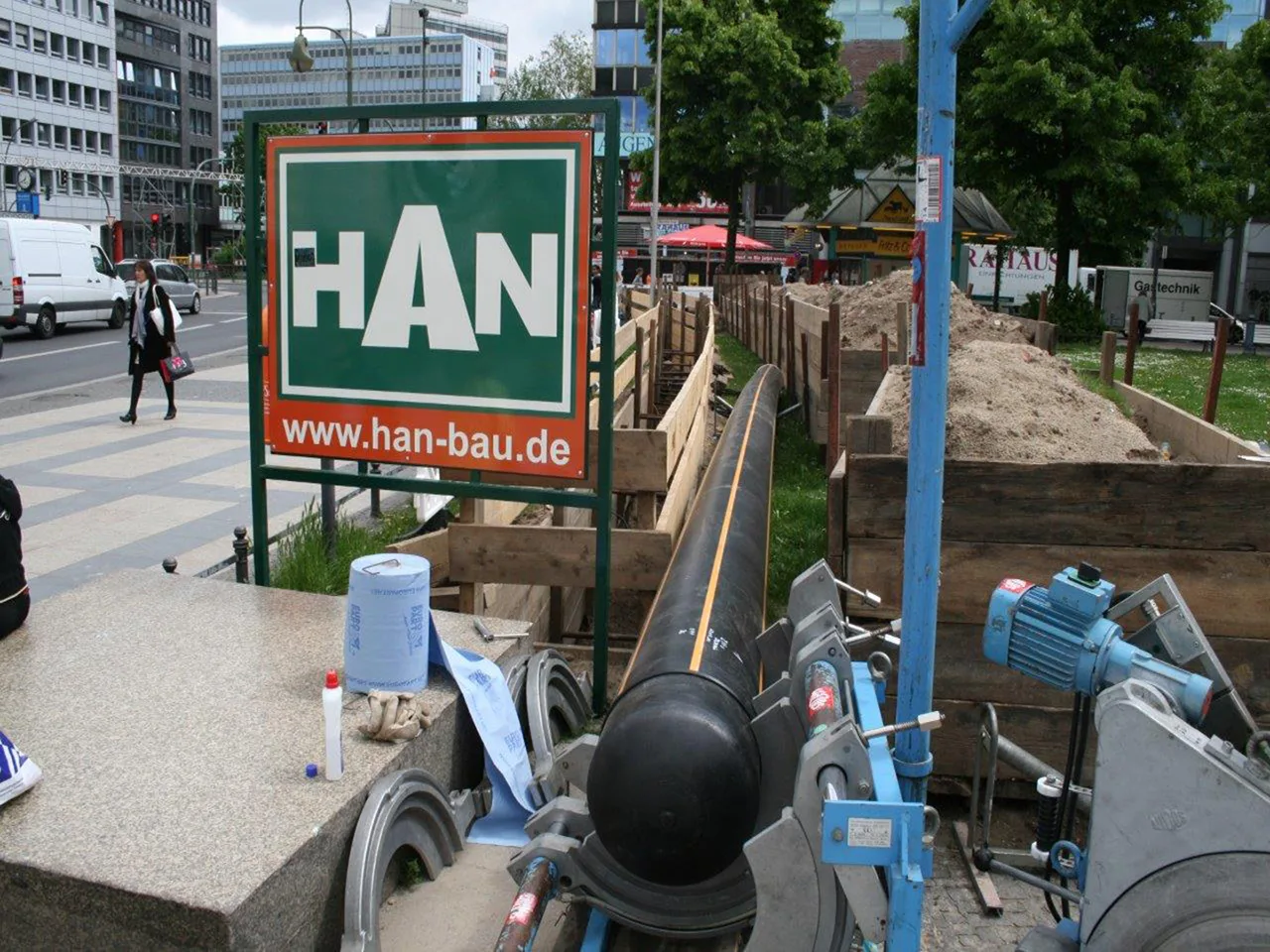 PE-Rohr in der Schweißmaschine vor einem HAN-Bauschild in Berlin
